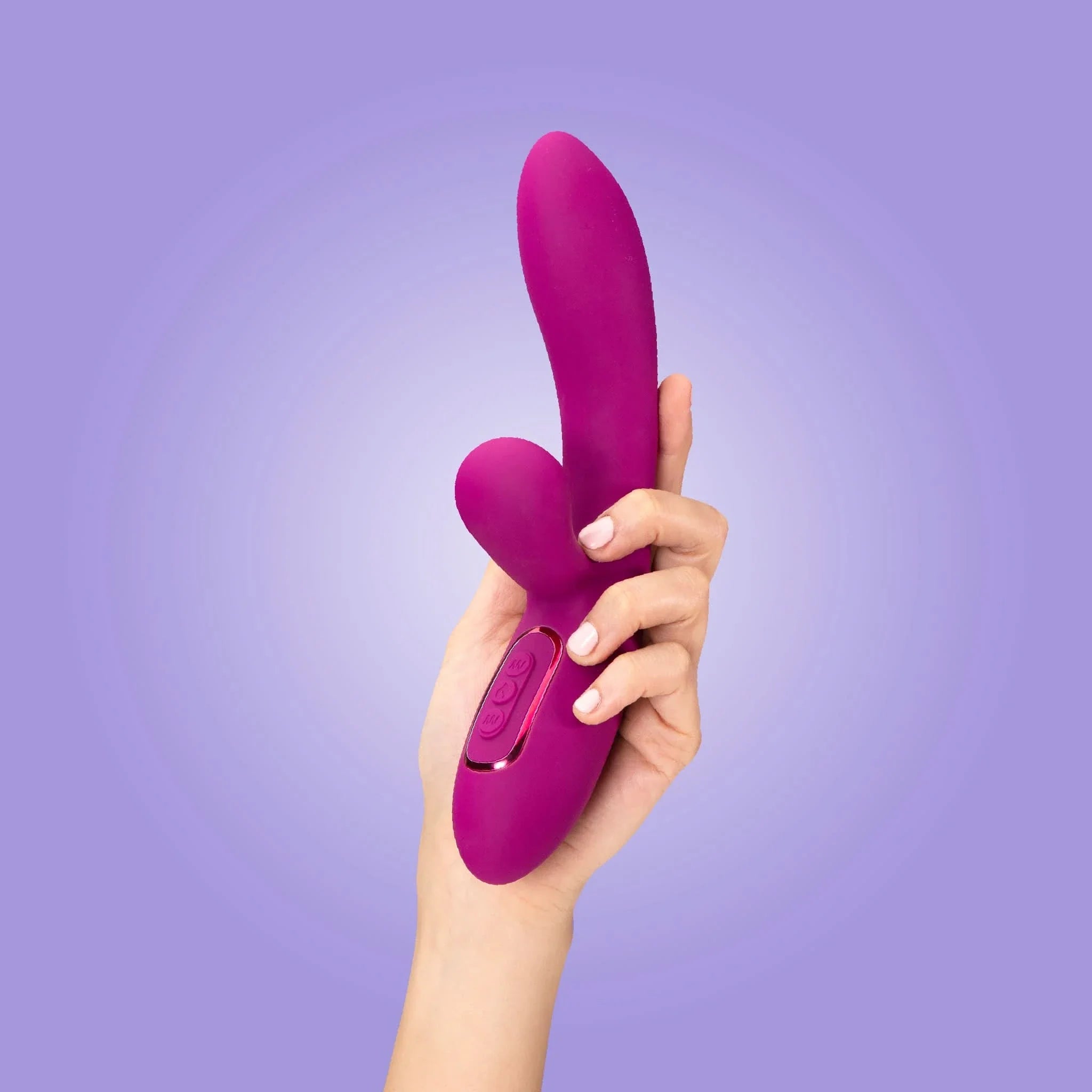 A hand holds the JIMMYJANE® Solis™ purple Rabbit vibrator with dual motors for stereophonic vibrations, set against a light purple background.