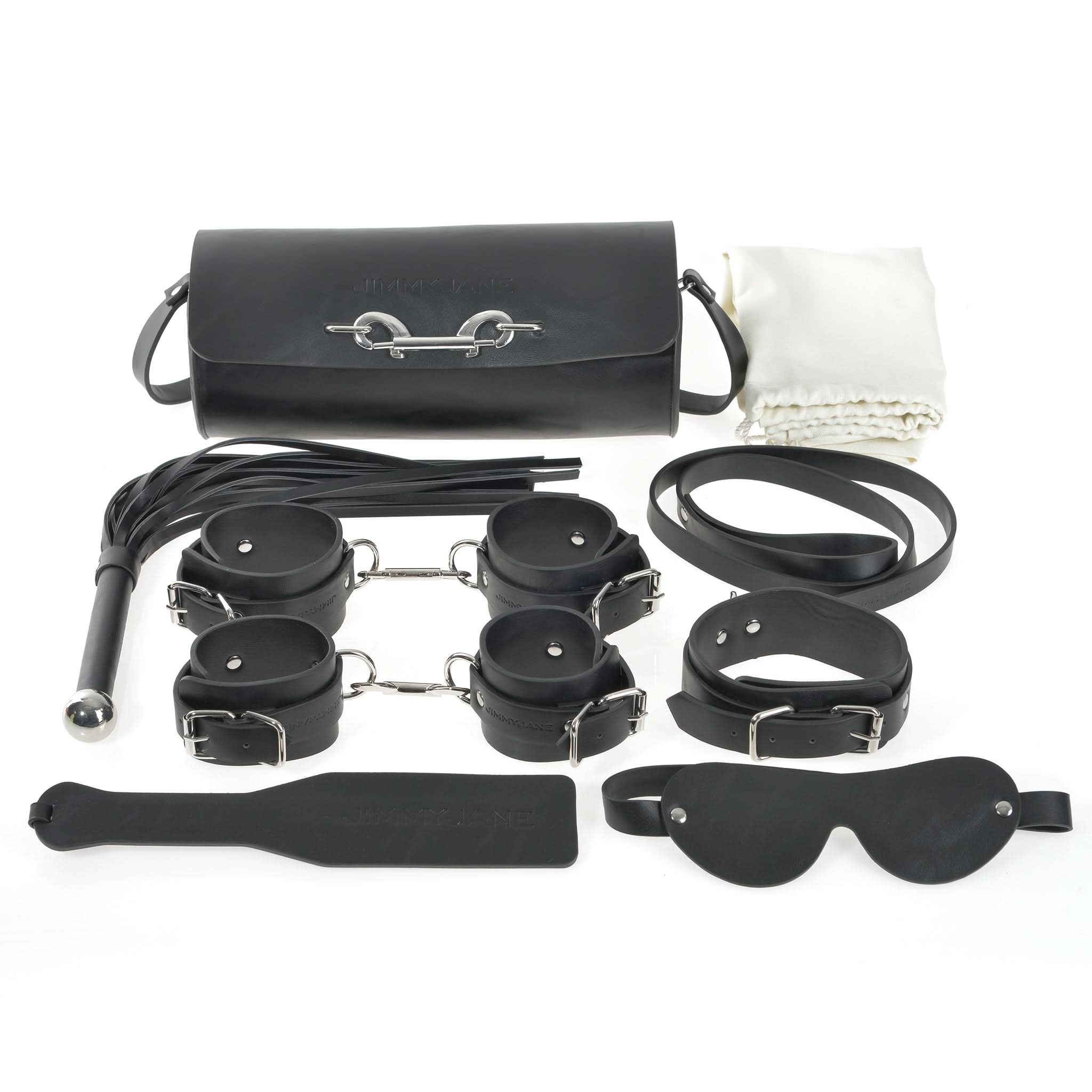 The JIMMYJANE® 7-Piece Bondage Set, made of black vegan leather, includes cuffs, paddle, whip, blindfold, collar, leash, carrying bag, and a white cloth—ideal for elevating any couple’s experience.